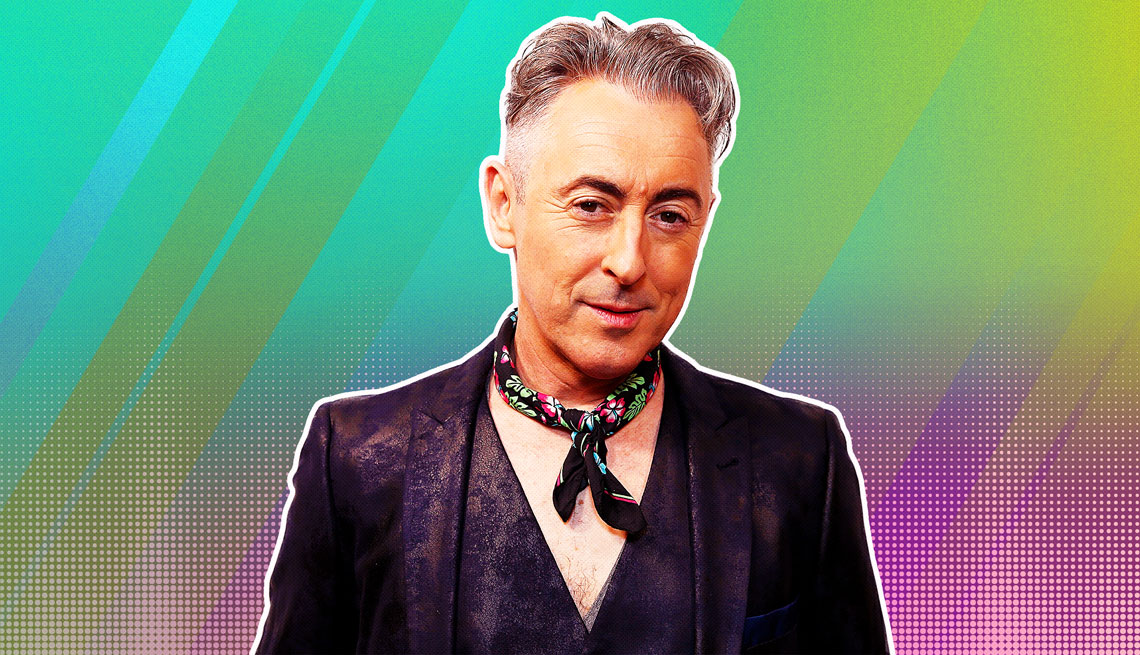 Alan Cumming outlined against a rainbow ombre background