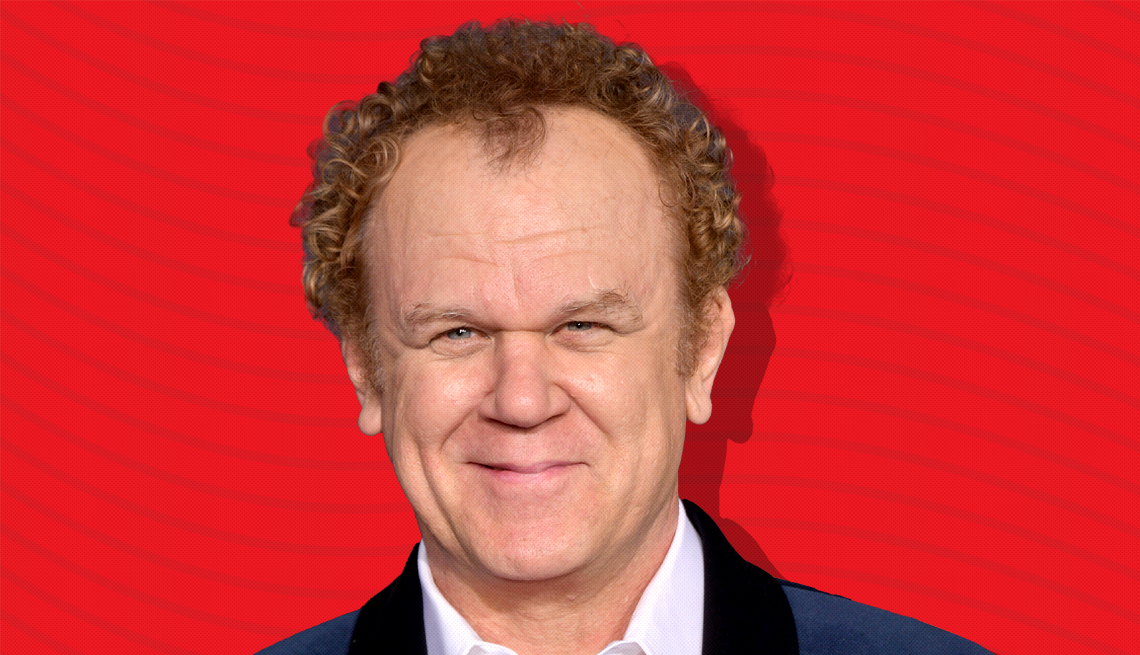 item 8 of Gallery image - john c reilly against red background with curved lines going horizontally from one end to the other
