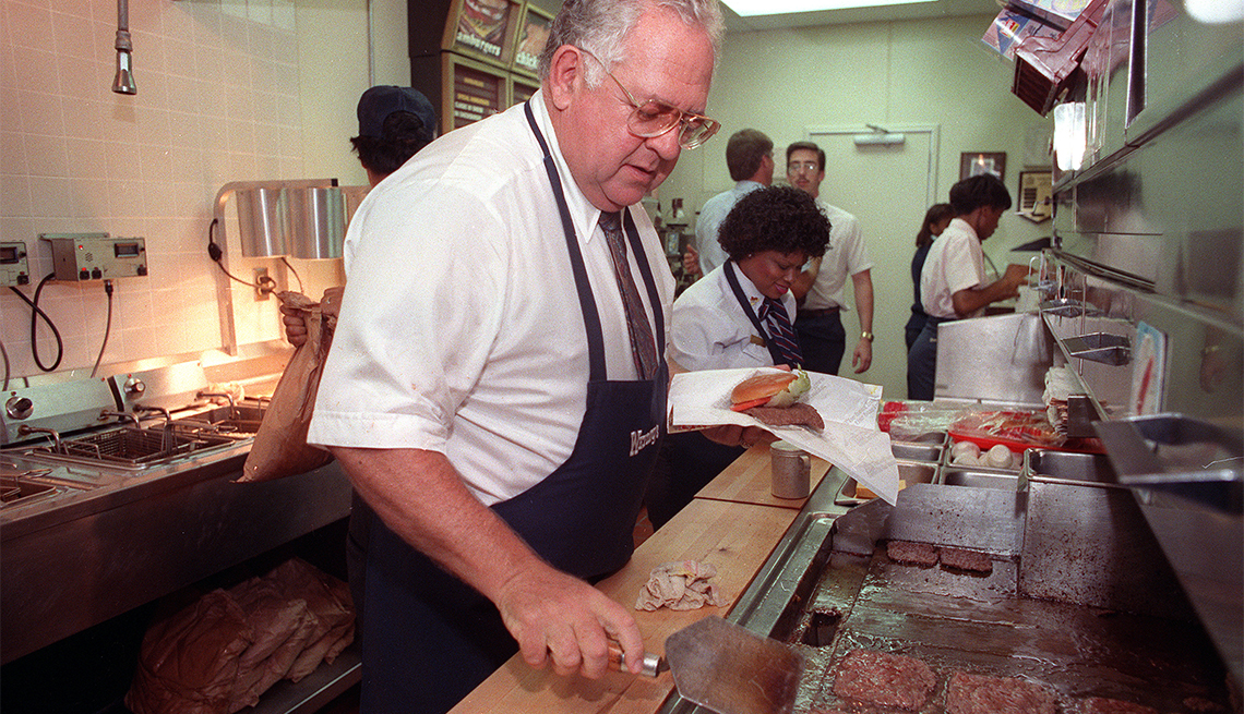 item 16 of Gallery image - Dave Thomas flipping burgers in a Wendy's kitchen with other employees