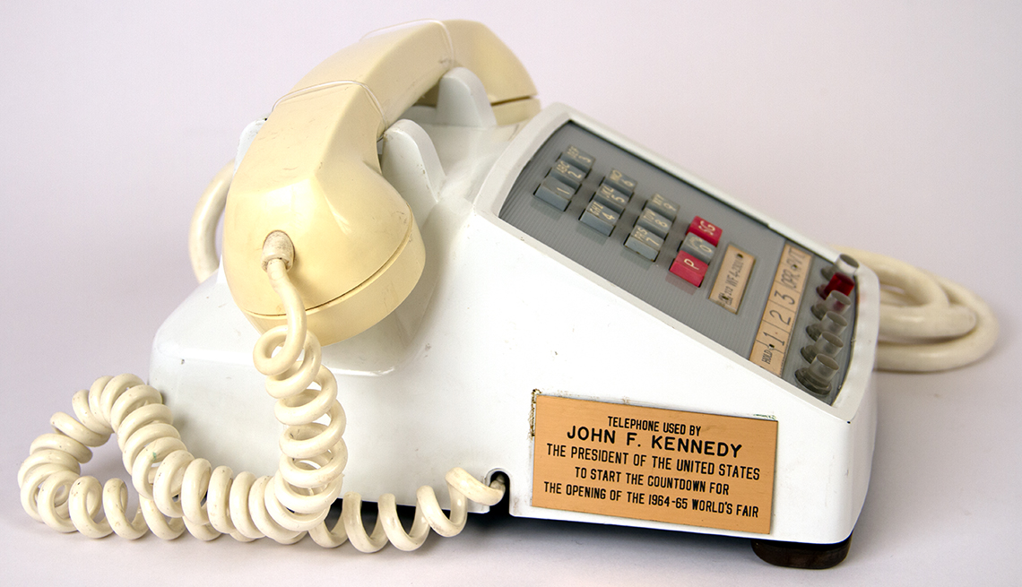 item 13 of Gallery image - white push-button phone with gold plaque stating it was used by President JFK to start the countdown for the opening of the 1964-65 World's Fair