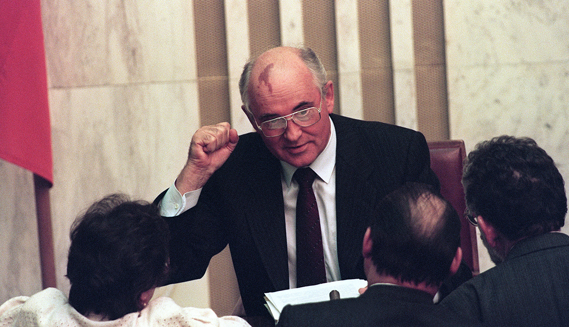 item 7 of Gallery image - Former USSR President Mikhail Gorbachev raises his fist while addressing several people who are facing him