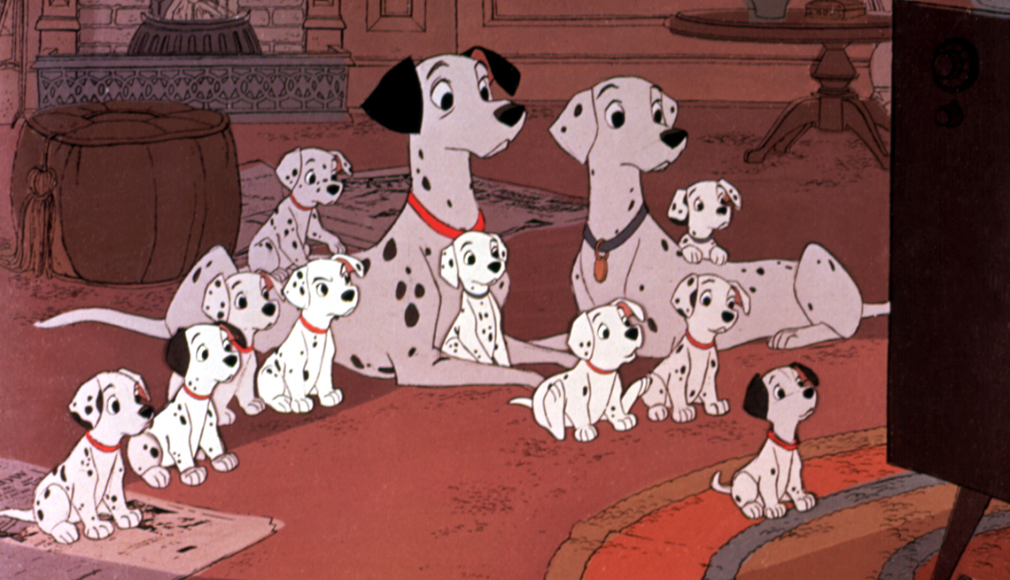 An animated still from '101 Dalmatians' shows a male and female Dalmatian amidst 10 puppies watching television