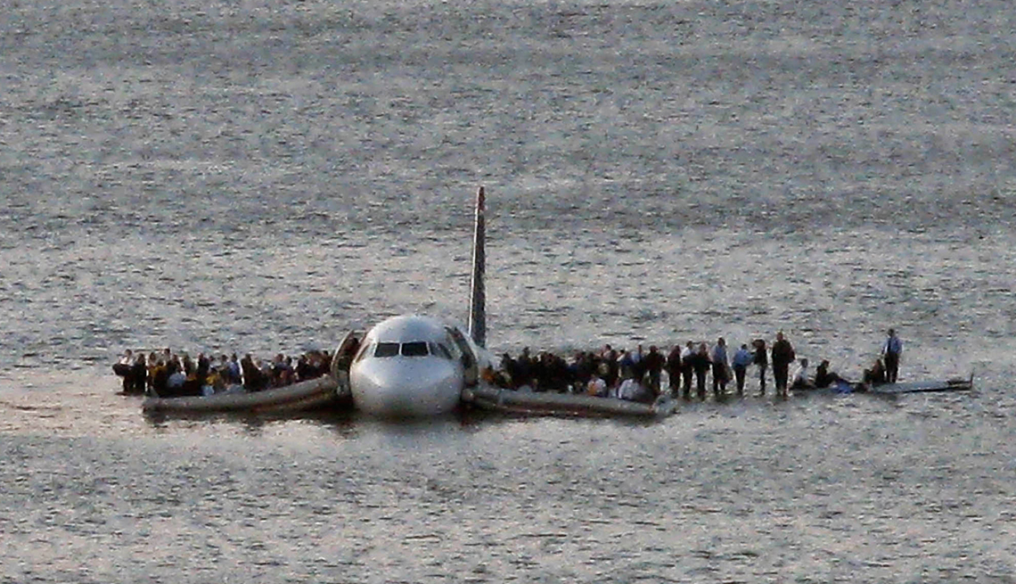 Passengers and crewmembers stand on the wings of US Airways Flight 1549 awaiting rescue after the plane landed in the Hudson River 