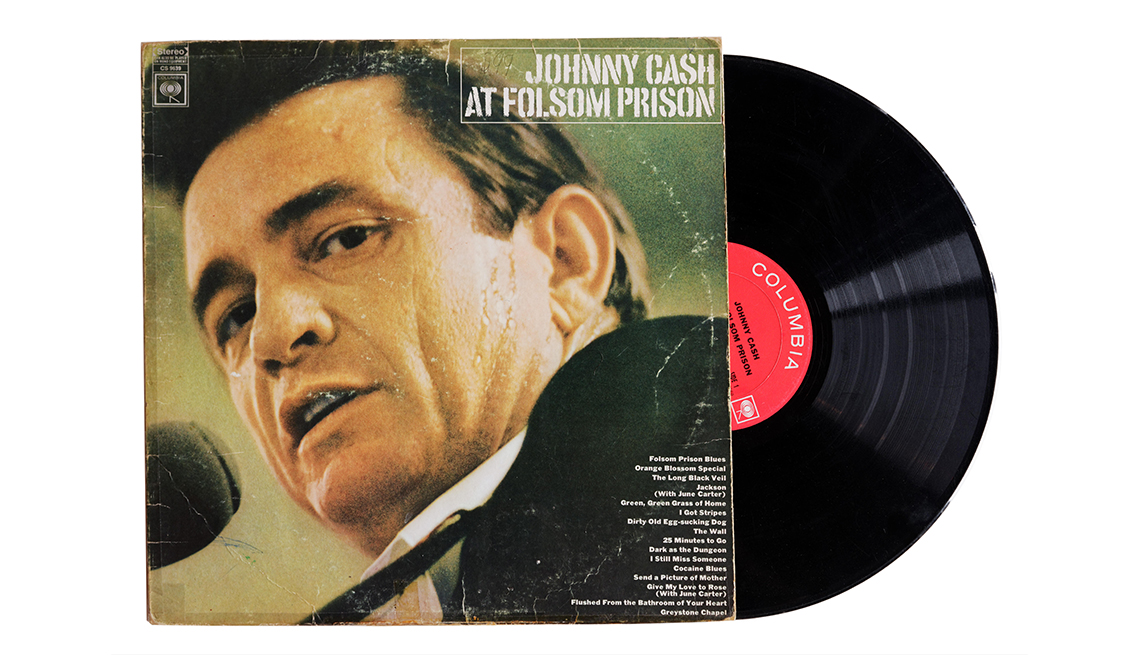 item 19 of Gallery image - A vinyl LP slides to the right out of the album cover of Johnny Cash’s ‘Live at Folsom Prison,’ shows the artist singing into a microphone