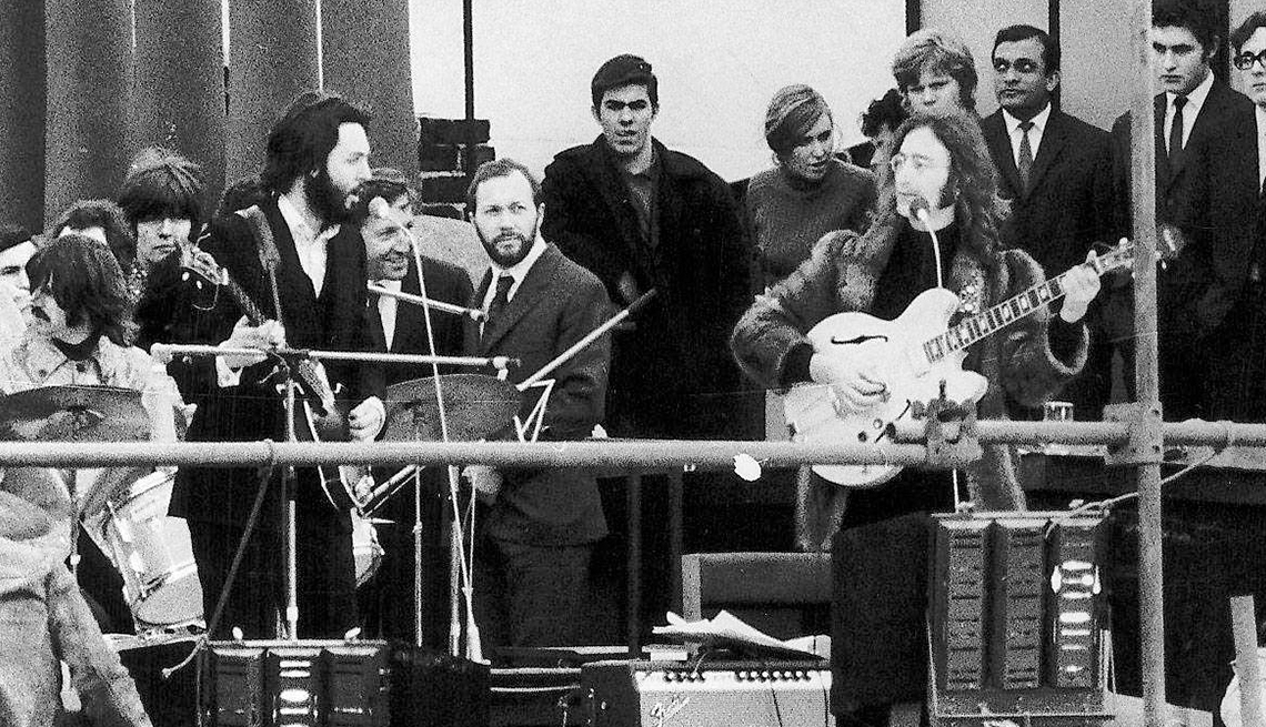 item 2 of Gallery image - A black and white image shows Beatles Paul McCartney and John Lennon facing each other in front of a small crowd during their last performance together