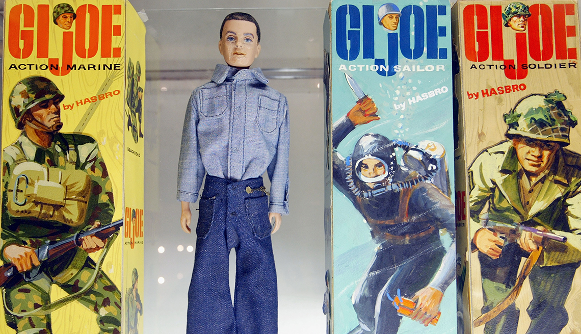 item 27 of Gallery image - a male doll dressed in blue is flanked by boxes displaying different GI Joe characters