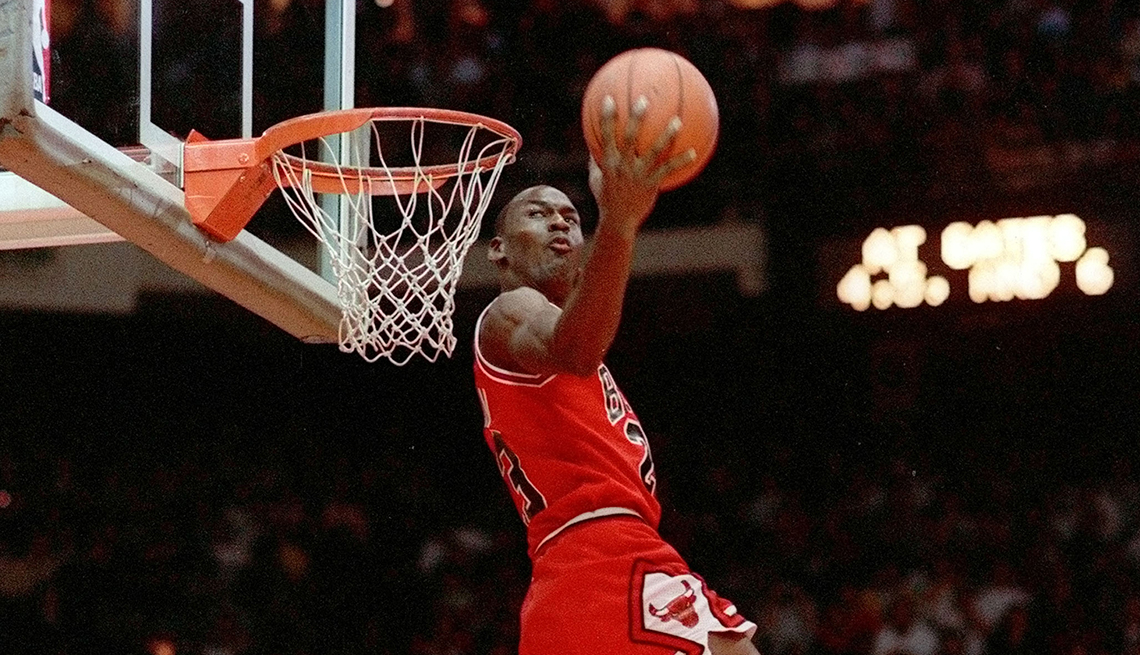 item 23 of Gallery image - Chicago Bulls player Michael Jordan is holding a basketball in front of the rim before dunking