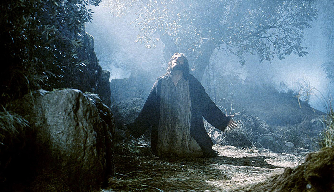 item 4 of Gallery image - Actor Jim Caviezel kneeling with his arms outstretched as he portrays Jesus Christ in the 2004 film ‘The Passion of the Christ’