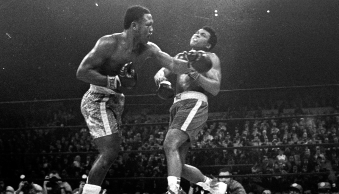 item 24 of Gallery image - a black and white photo shows Muhammad Ali's chin whipping back after receiving a left hook from Joe Frazier during a boxing match