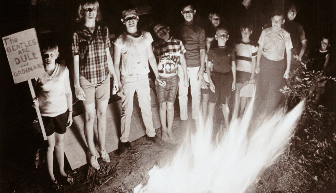 item 28 of Gallery image - a black and white picture of teenagers surrounding a fire