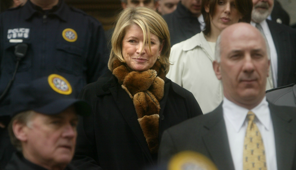 item 27 of Gallery image - Martha Stewart is wearing a fur scarf and a black coat while being surrounded by police and other people
