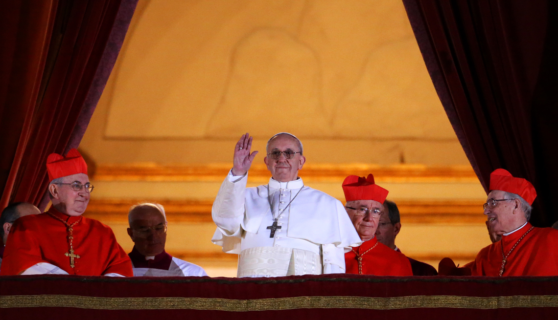 item 19 of Gallery image - pope francis is wearing white robes and surrounded by red robed cardinals as he waves from a balcony