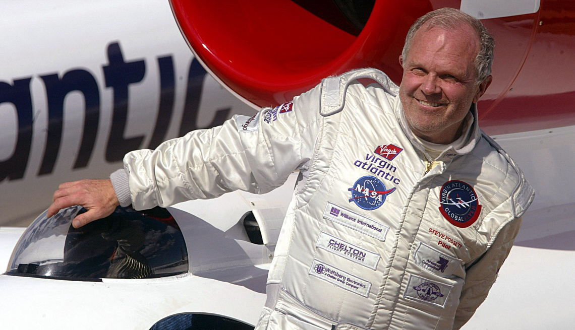item 29 of Gallery image - Steve Fossett climbs out of a cockpit wearing a white flight suit and smiling