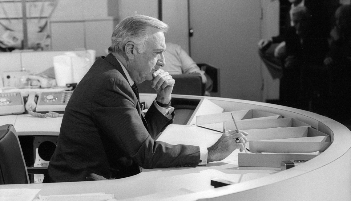 item 26 of Gallery image - a black and white image of Walter Cronkite sitting at a desk and holding a pen