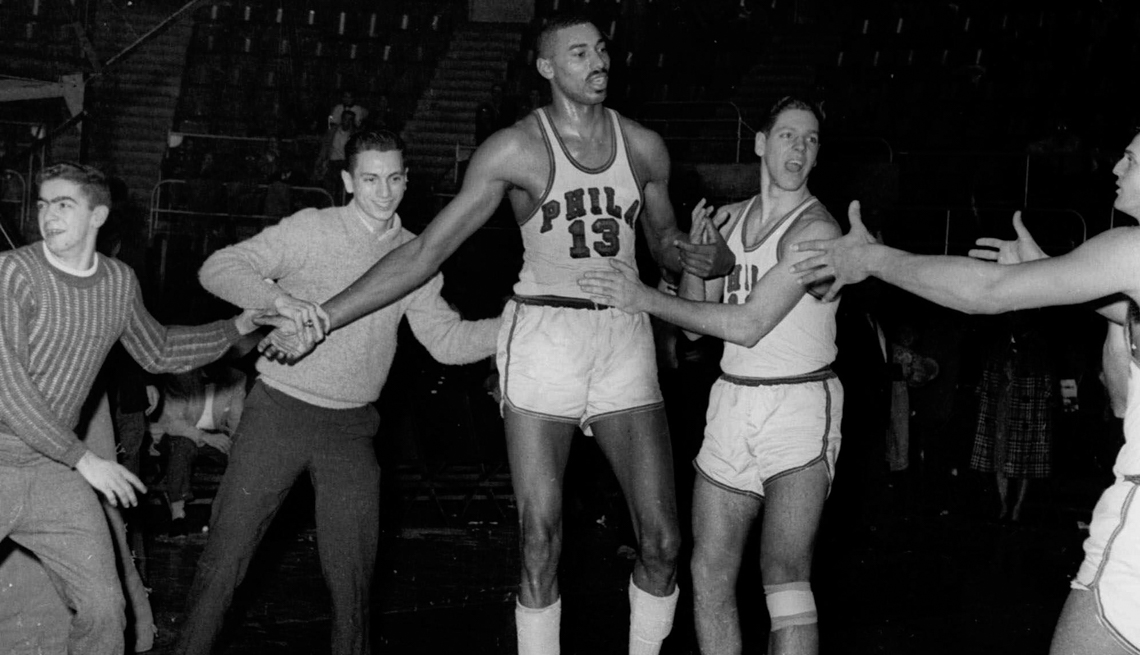 item 30 of Gallery image - a black and white photo of Wilt Chamberlain surrounded by players and fans
