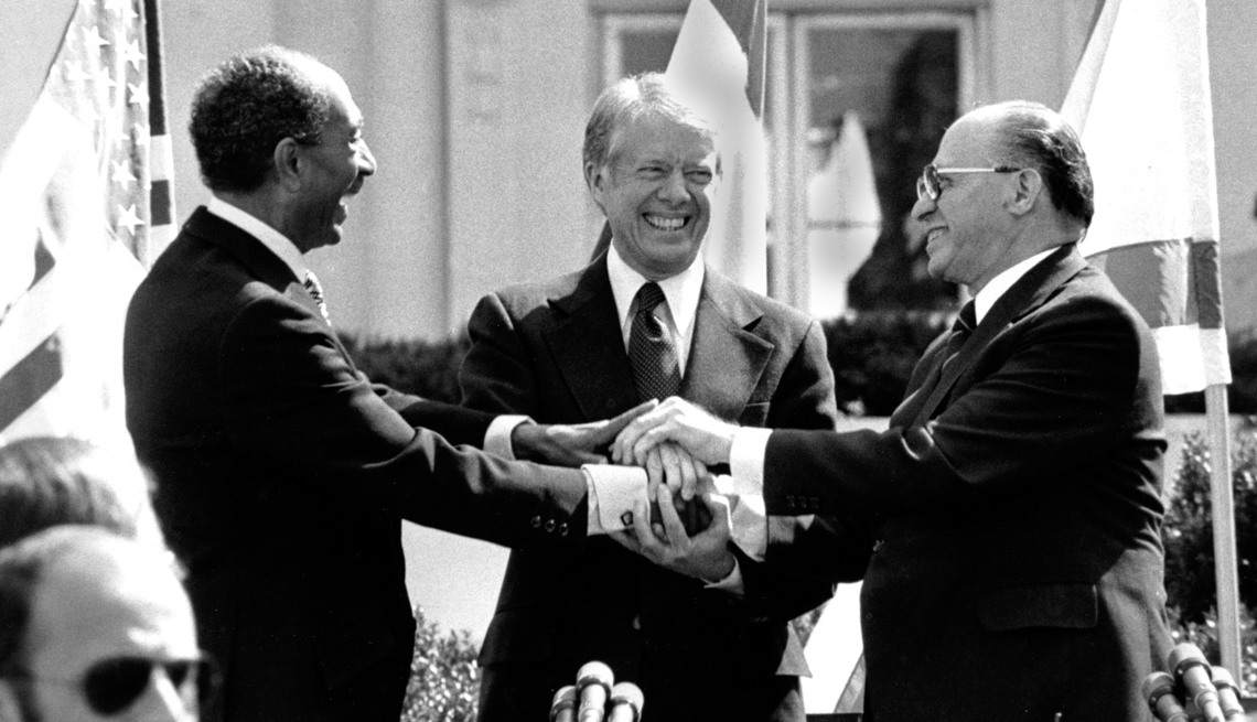 item 6 of Gallery image - Egyptian President Anwar Sadat, left, U.S. President Jimmy Carter, center,  and Israeli Prime Minister Menachem Begin clasp hands on the north lawn of the White House after signing the peace treaty between Egypt and Israel on March 26, 1979.