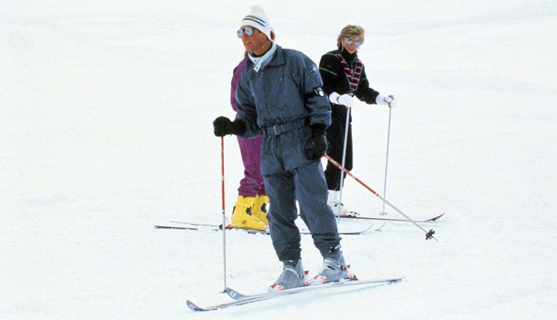 item 22 of Gallery image - prince charles on skis and wearing a gray outfit, white hat and ski gloves with princess diana and sarah ferguson in the background