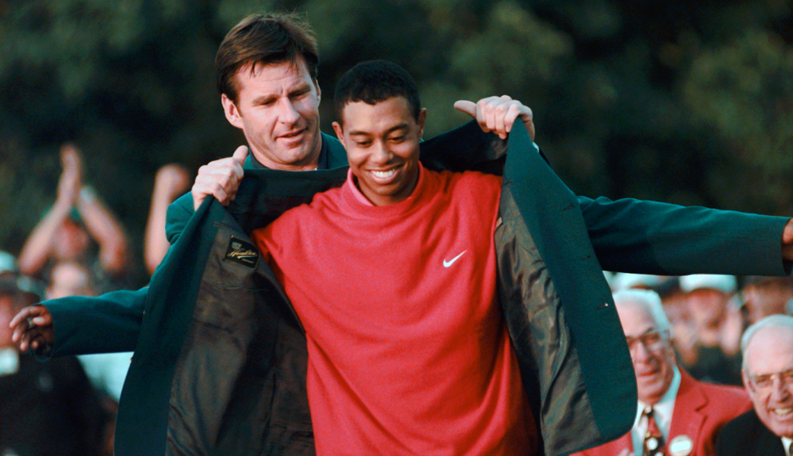 item 18 of Gallery image - Masters champion Tiger Woods receives his Green Jacket from last year's winner Nick Faldo, left, at the Augusta National Golf Club in Augusta, Ga.