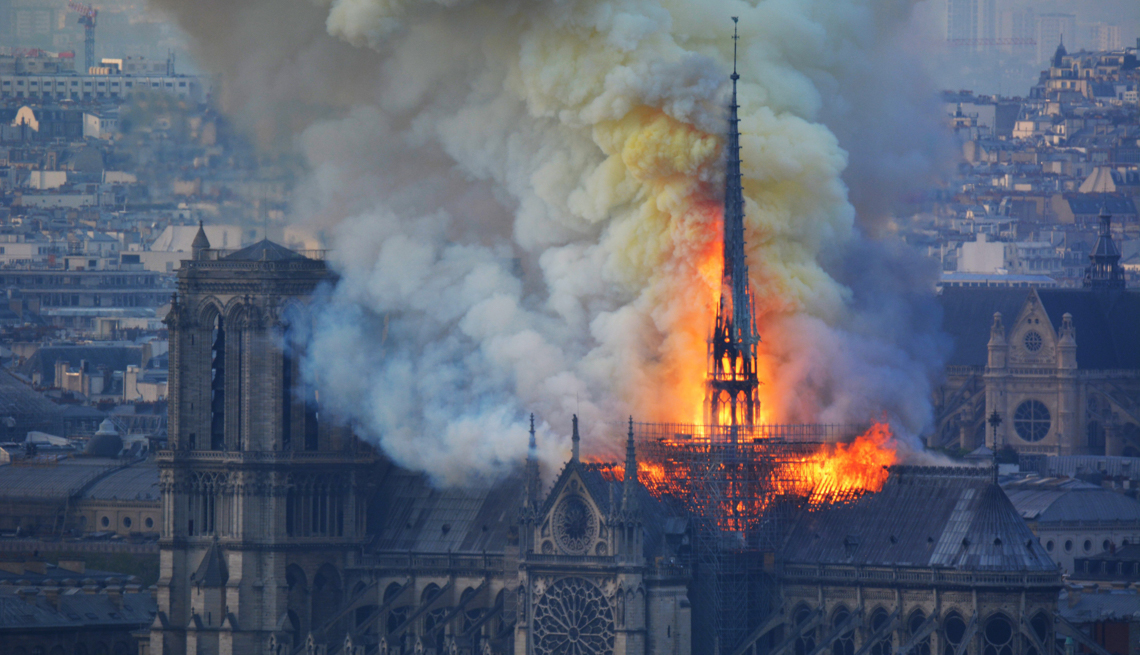 item 16 of Gallery image - Smoke and flames rise during a fire at the landmark Notre-Dame Cathedral in central Paris on April 15, 2019