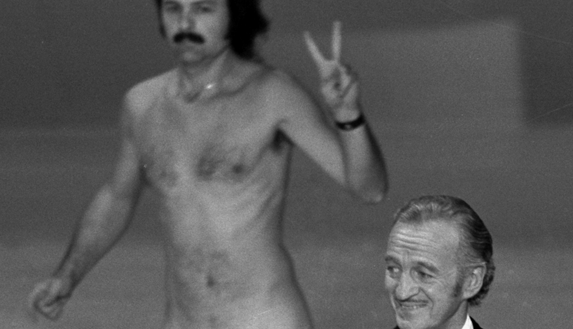 item 29 of Gallery image - Robert Opel streaks behind Oscar presenter David Niven on stage near the end of the 1974 Academy Awards show in Los Angeles.