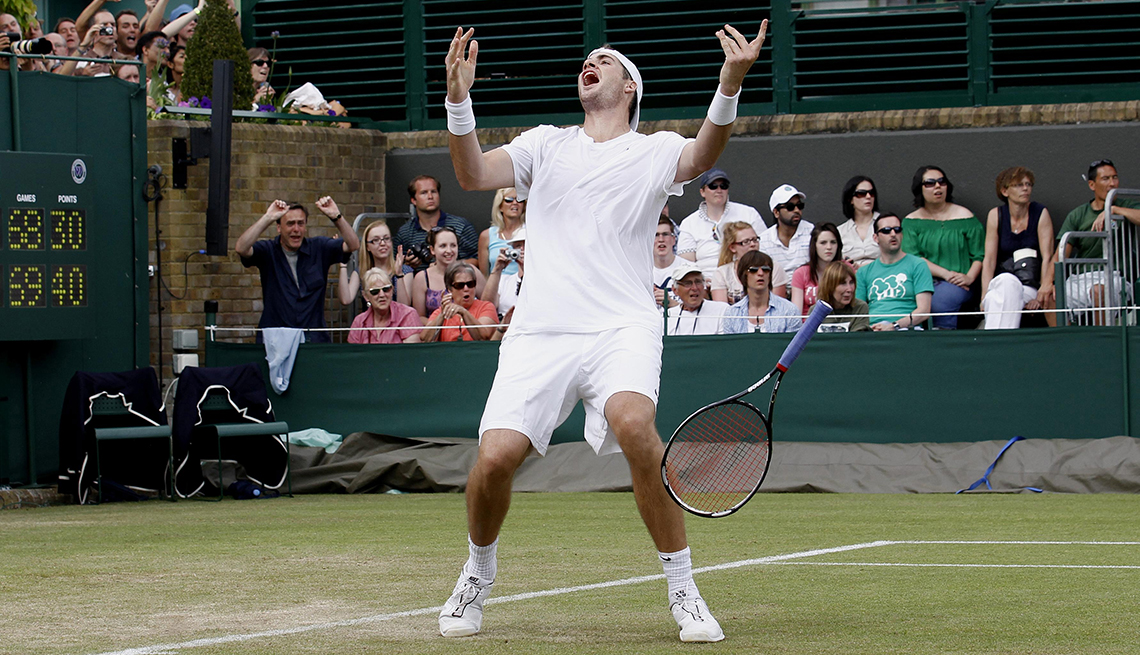 USA's John Isner celebrates victory over France's Nicolas Mahut in their record breaking match on Court 18 during Day Four of the 2010 Wimbledon Championships