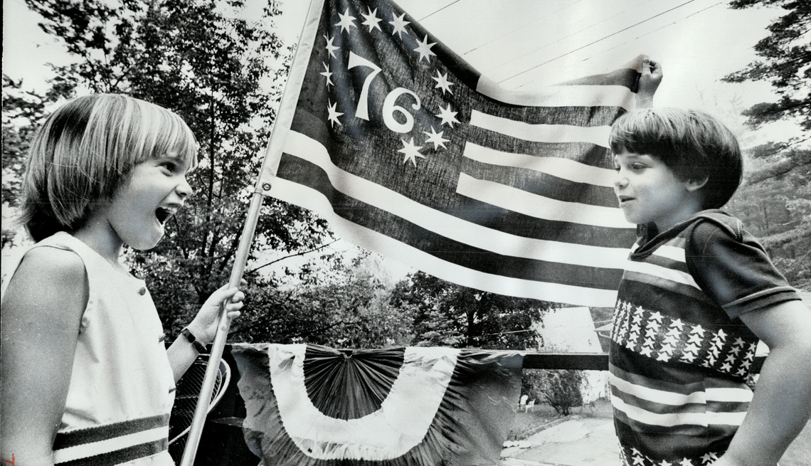 A girl and boy with a spirt of 76 American flag