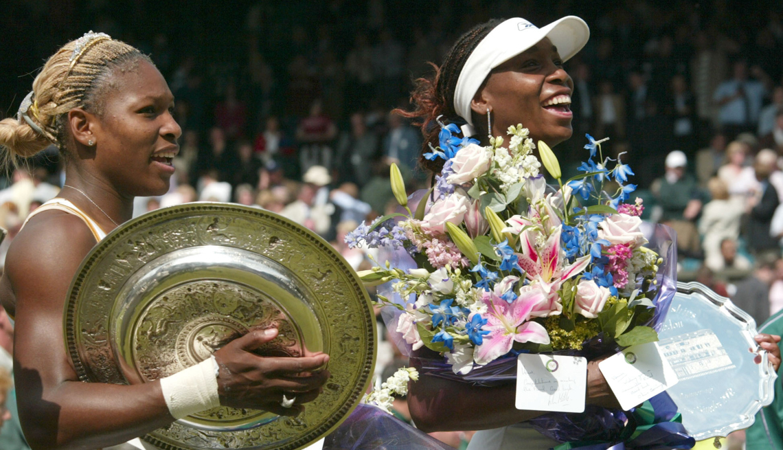 item 2 of Gallery image - Serena Williams, left, holds her trophy after defeating her sister Venus, right, to win the Women's Singles final on the Centre Court  at the All England Lawn Tennis Championships