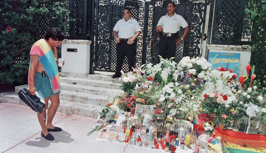 item 17 of Gallery image - A beach goer stops to read and look at notes and flower arrangements left by wellwishers on the steps of the house of slain Italian designer Gianni Versace