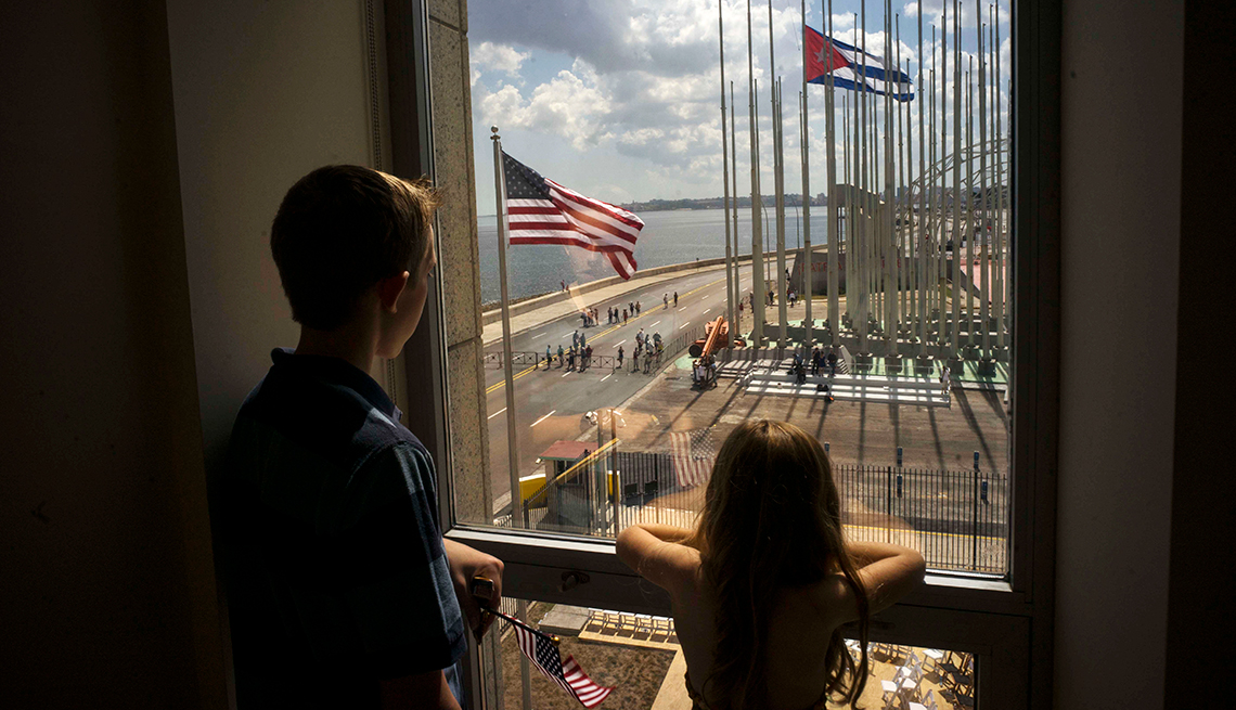 item 18 of Gallery image - A boy and a girl look out a window at the U.S. Embassy in Havana