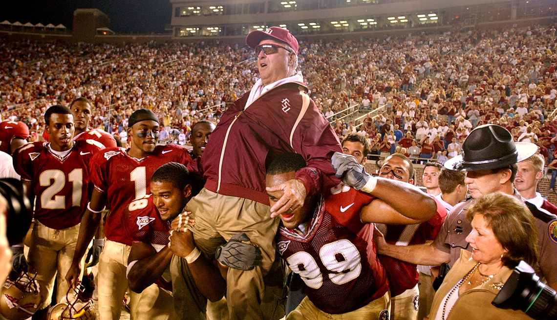 item 7 of Gallery image - coach bobby bowden lifted in the air by football players in a packed stadium