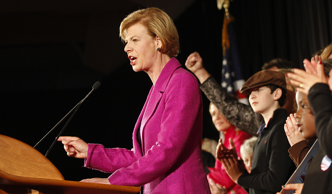 item 25 of Gallery image - united states representative tammy baldwin standing at podium speaking with people clapping behind her