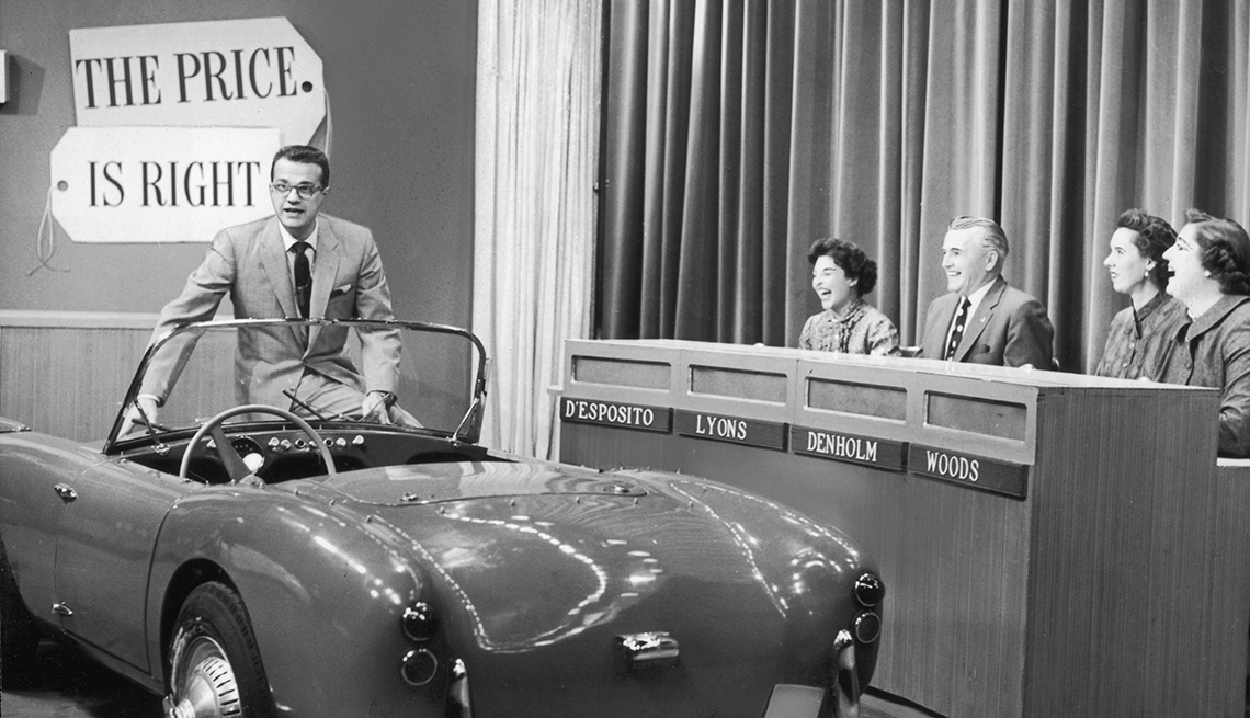 item 5 of Gallery image - bill cullen sits on edge of convertible sports car as four contestants laugh in a black and white still from the price is right