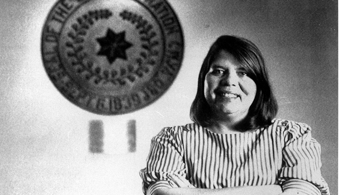 item 18 of Gallery image - wilma mankiller posing in front of tribal emblem at cherokee nation