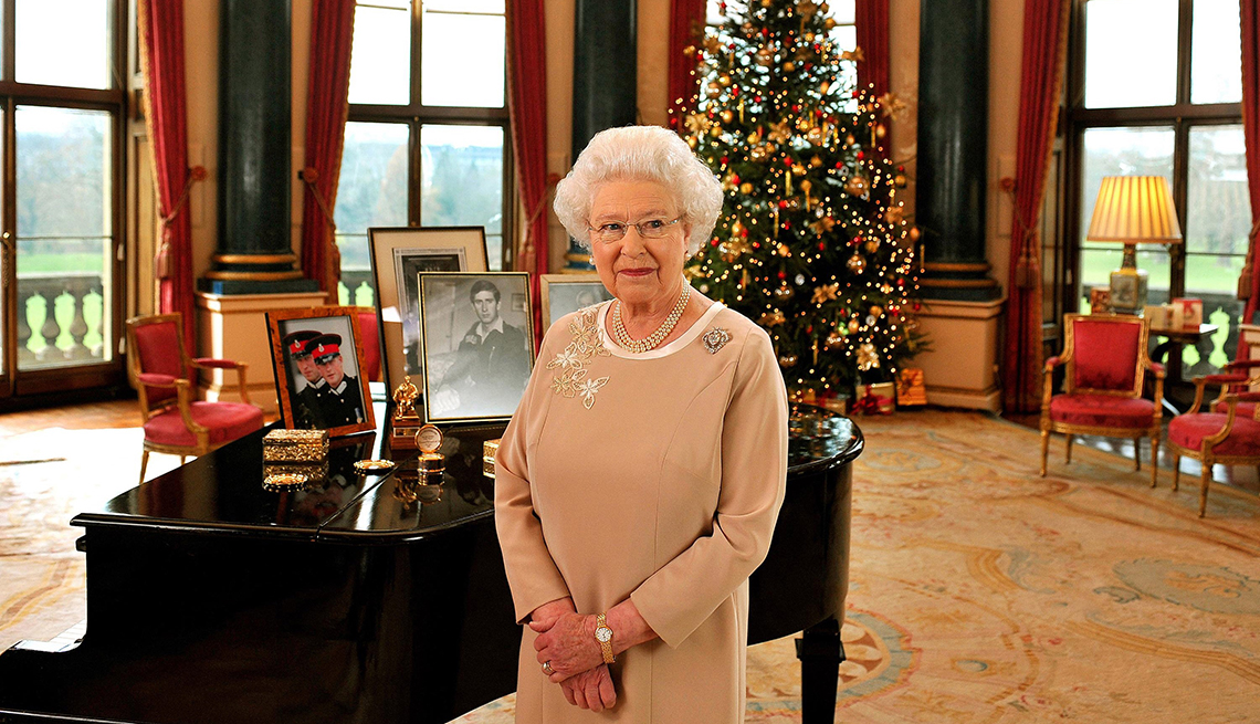item 12 of Gallery image - queen elizabeth the second standing in front of piano with photos on it; christmas tree in the background
