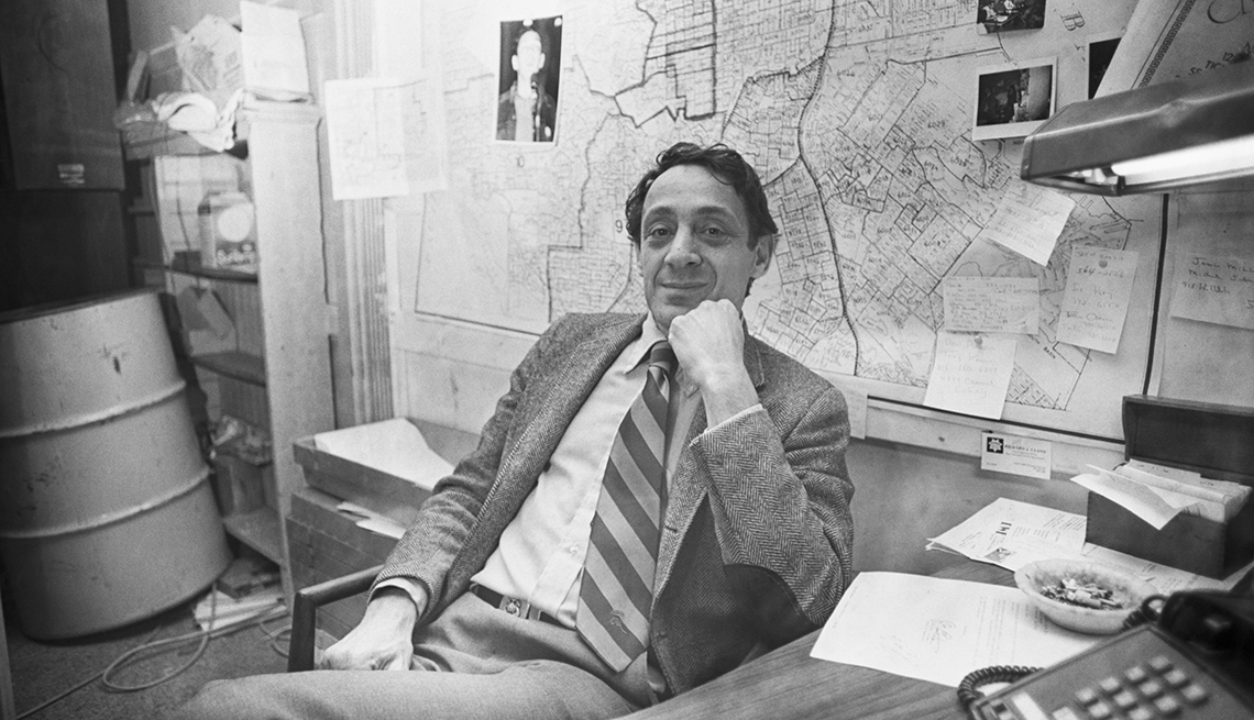 item 24 of Gallery image - harvey milk siting in chair behind desk; papers all over wall behind him