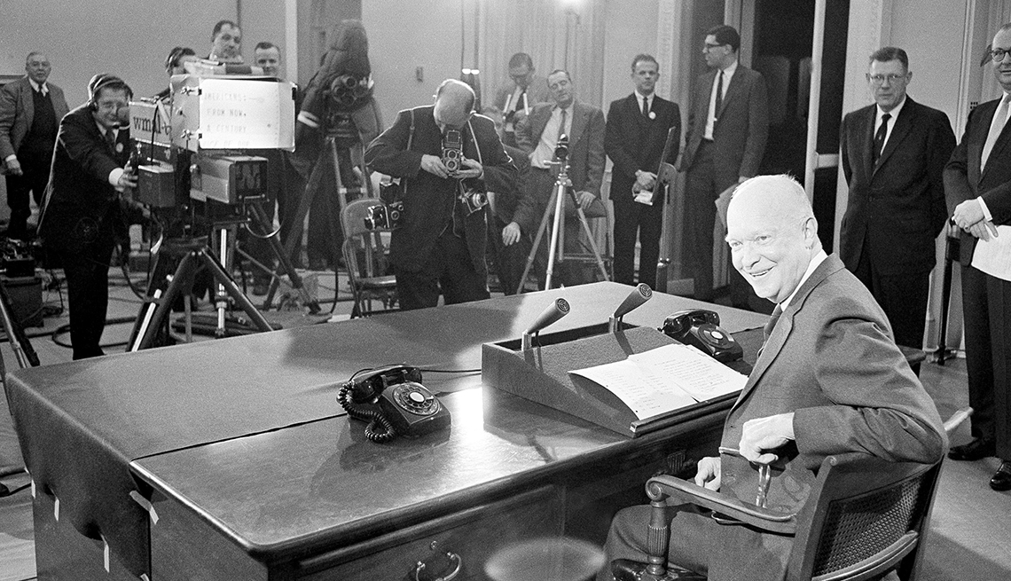 item 15 of Gallery image - president eisenhower sitting at desk with cameras pointed at him; at right is white house press secretary james hagerty