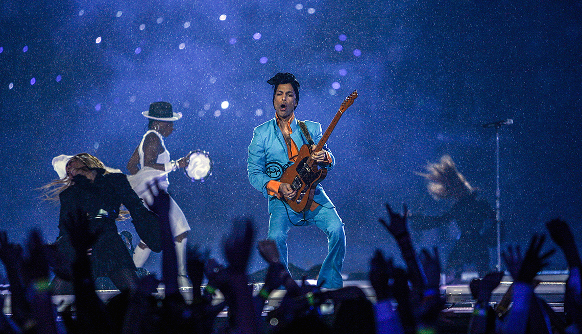 item 25 of Gallery image - prince performing on a stage with dancers around him and a crowd of people with hands up in front of him