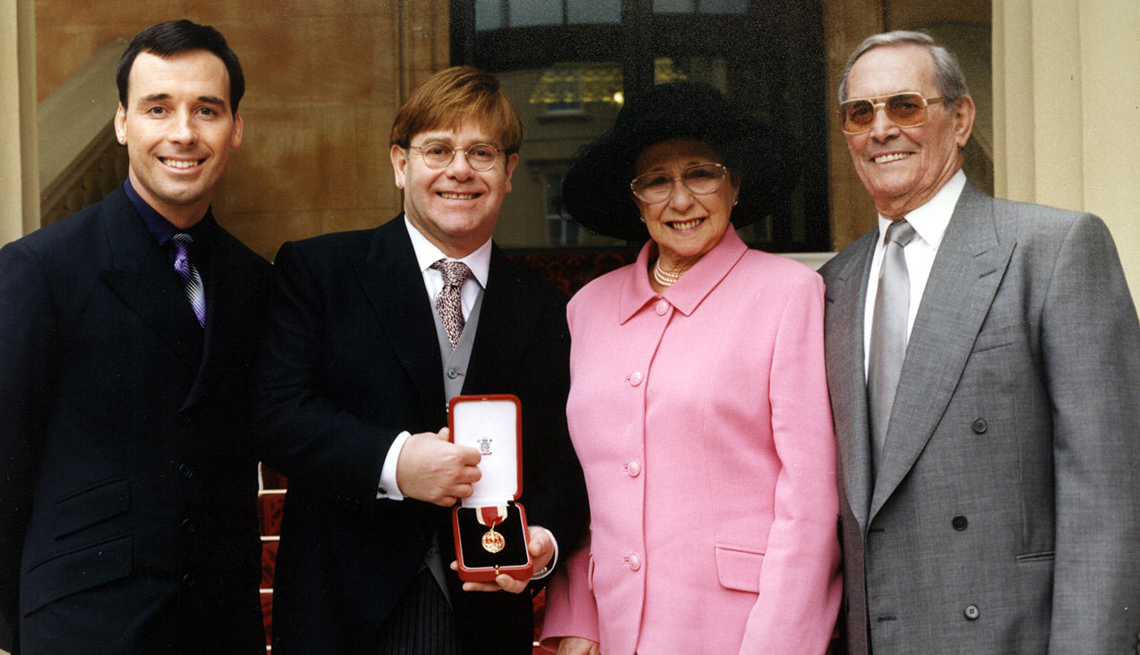 item 5 of Gallery image - elton john standing with his partner david furnish, mother sheila and stepfather fred fairebrother outside buckingham palace