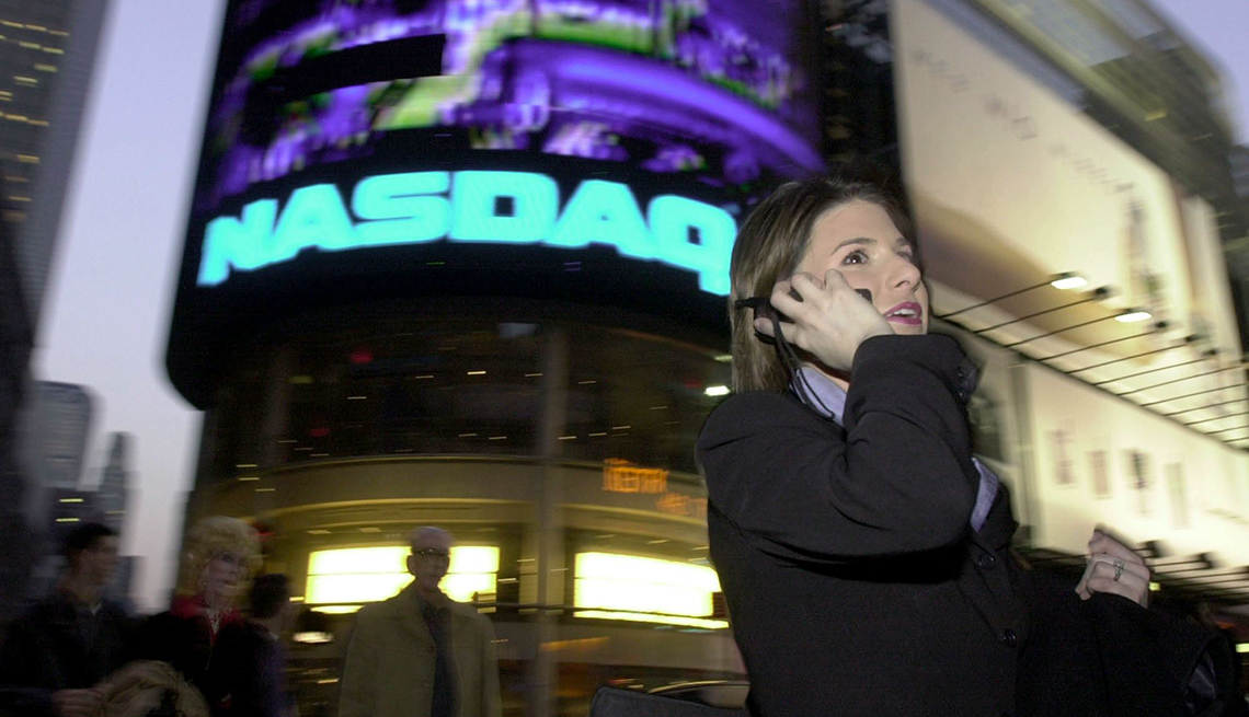 item 10 of Gallery image - woman talking into a cell phone in front of Nasdaq sign