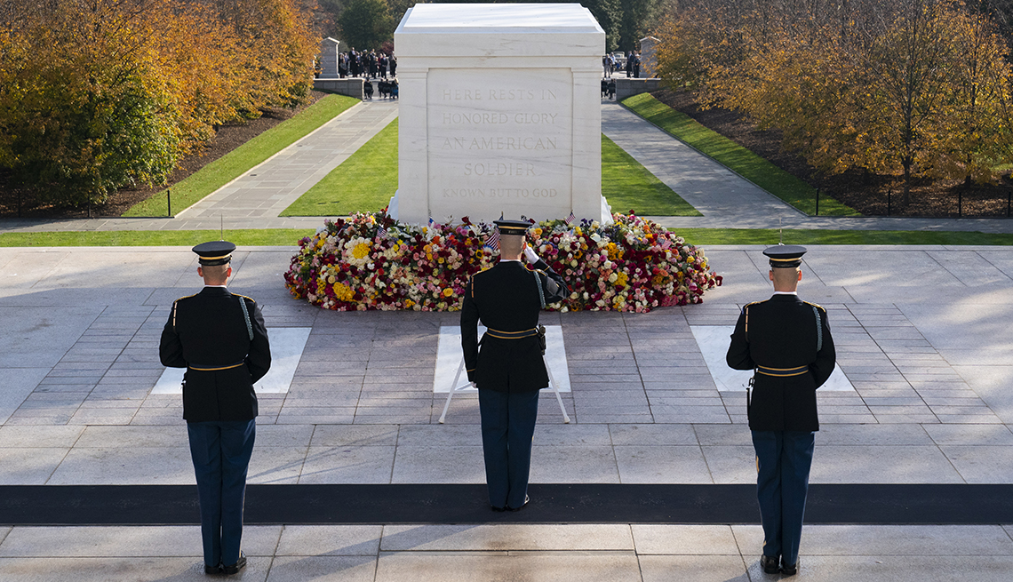 a tomb guard saluting the tomb of the unknown soldier at arlington national cemetery