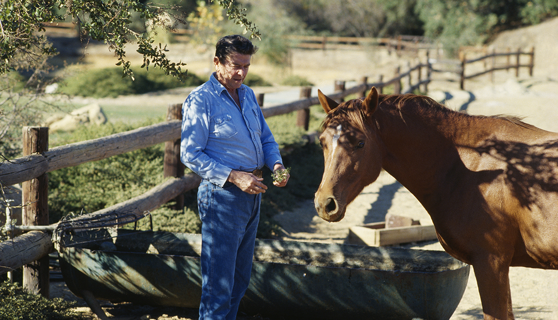 ronald reagan outside in front of a horse