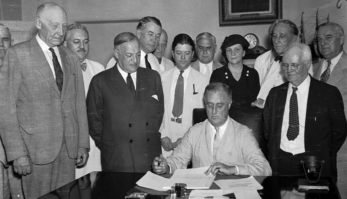 item 18 of Gallery image - President Franklin D. Roosevelt signing the Social Security bill. From left, are: Chairman Doughton of the House Ways and Means Committee; Sen. Wagner, D-N.Y, co-author of the bill, Secretary Perkins, Chairman Harrison of the Senate Finance Committe, Rep. Lewis, D-Md., co-author of the measure.