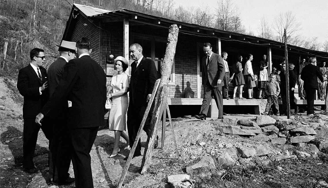 item 12 of Gallery image - President Lyndon Johnson and his wife, Lady Bird leaving the home in Inez, Ky., of Tom Fletcher, a father of eight who told Johnson he'd been out of work for nearly two years