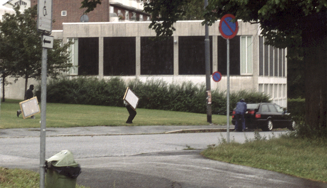 item 10 of Gallery image - Armed robbers who raided the Munch Museum in Oslo running to get into the waiting getaway car outside the museum to load the paintings into the back of the car