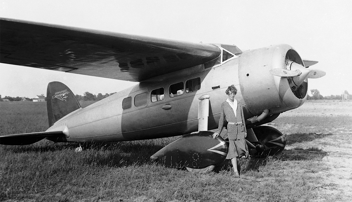 item 8 of Gallery image - Noted Aviatrix Amelia Earhart is shown standing beside a monoplane