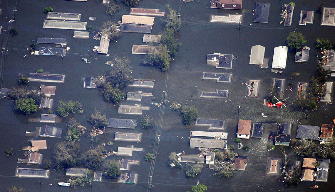 item 2 of Gallery image - A U.S. Coast Guard helicopter passes over a flooded neighborhood east of downtown New Orleans