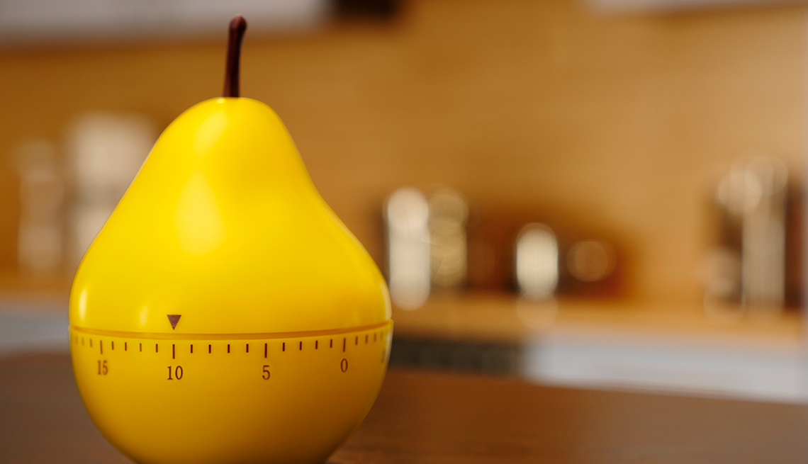 timer in the shape of a yellow pear set to 10 minutes on a kitchen counter