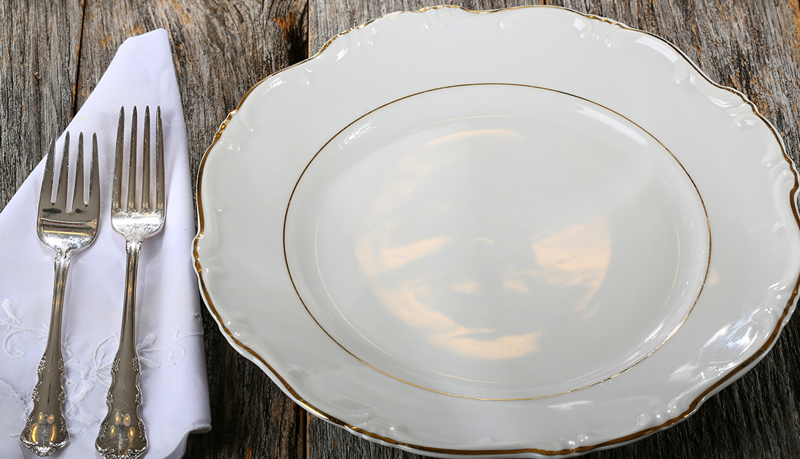 fine china dinner plate and silverware on fancy white napkin