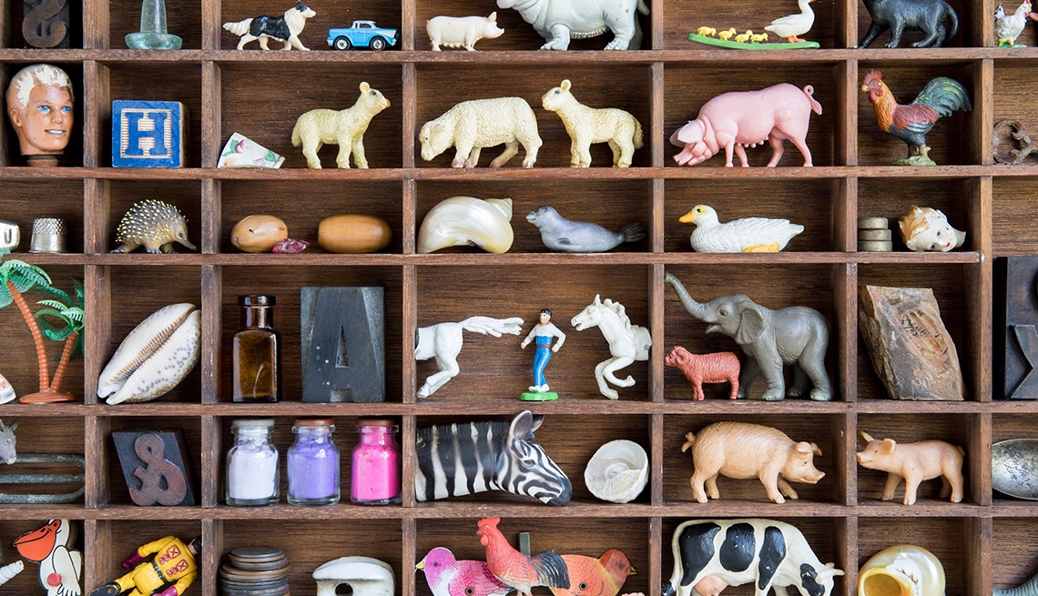 little animal figures and other collectibles organized in wooden box frame
