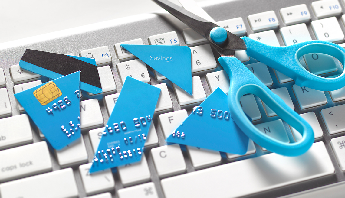blue scissors and cut up credit card on computer keyboard